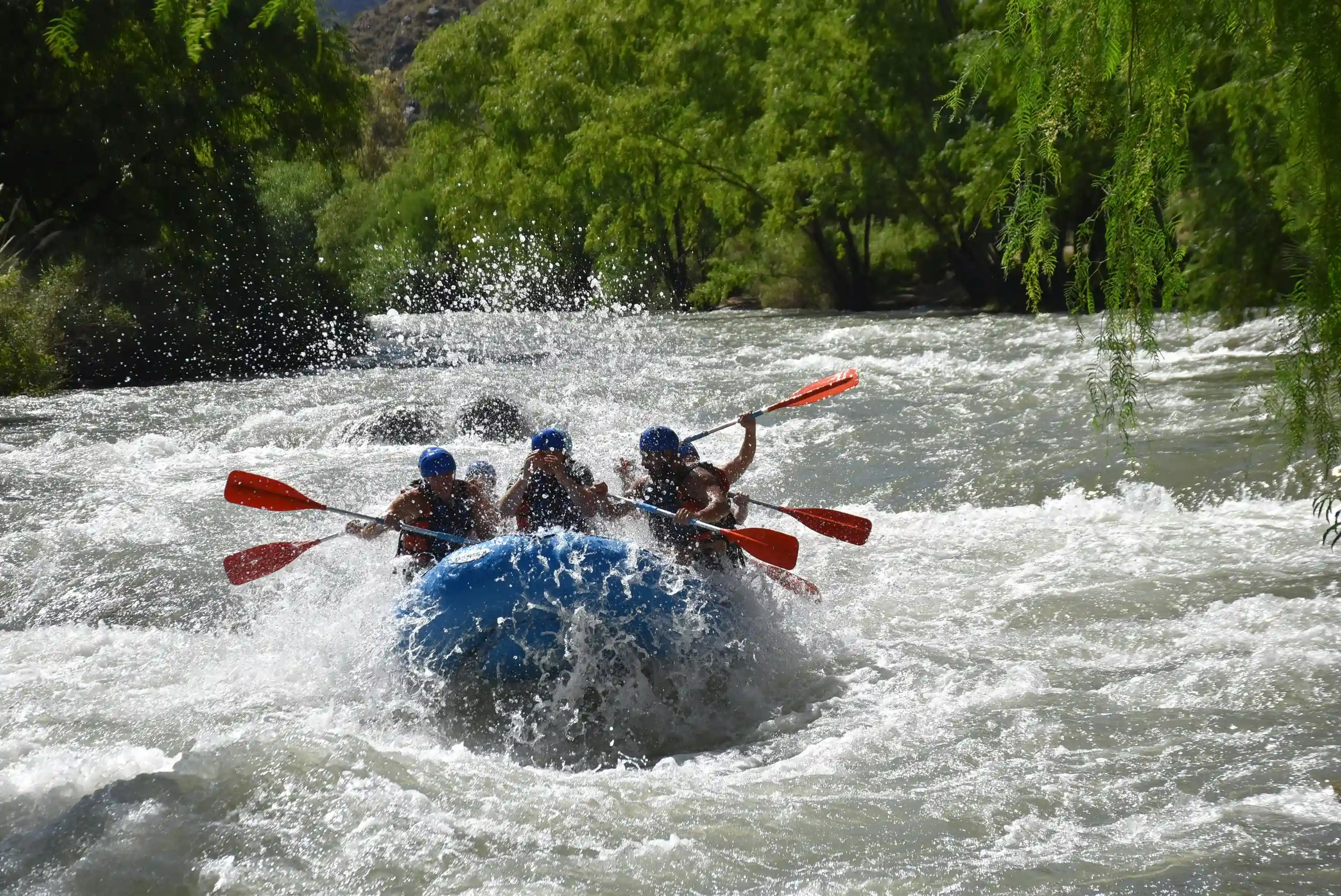 group smiling and laughing as they paddle down the Arkansas River